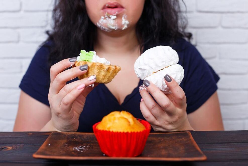ჭარბი წონა ქალი ჭამს ტკბილეულს